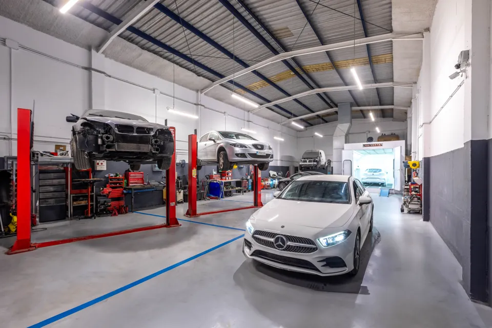 Nave del taller con elevadores y un Mercedes Clase A en reparación