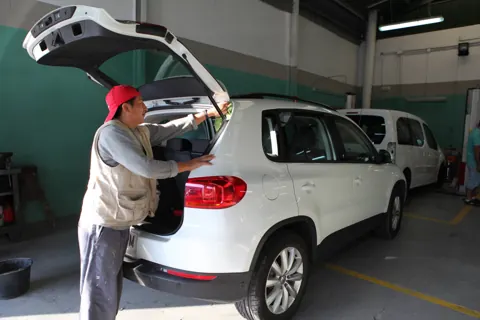 Mecánico ajustando el portón trasero de un Volkswagen